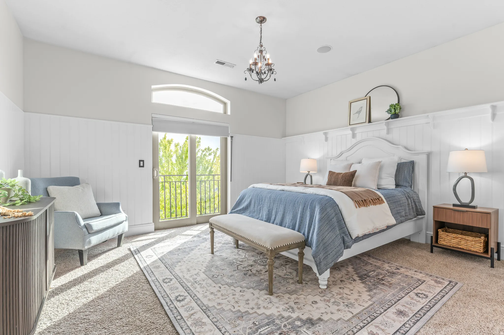 Board and batten wall detailing, arched transom window, French doors with balcony, recessed lighting, and a chandelier