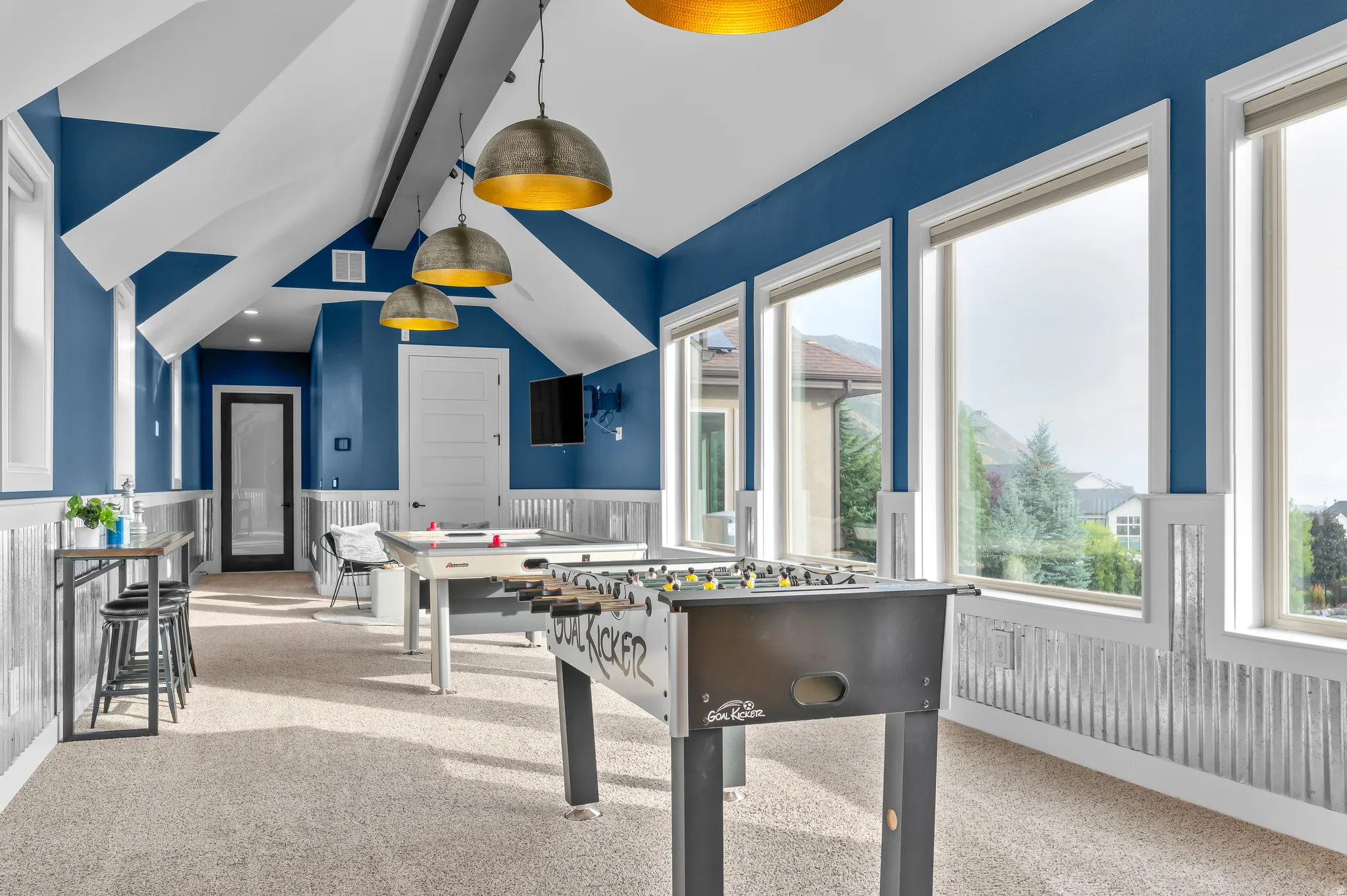 Carpeted room with vaulted ceilings and exposed beams