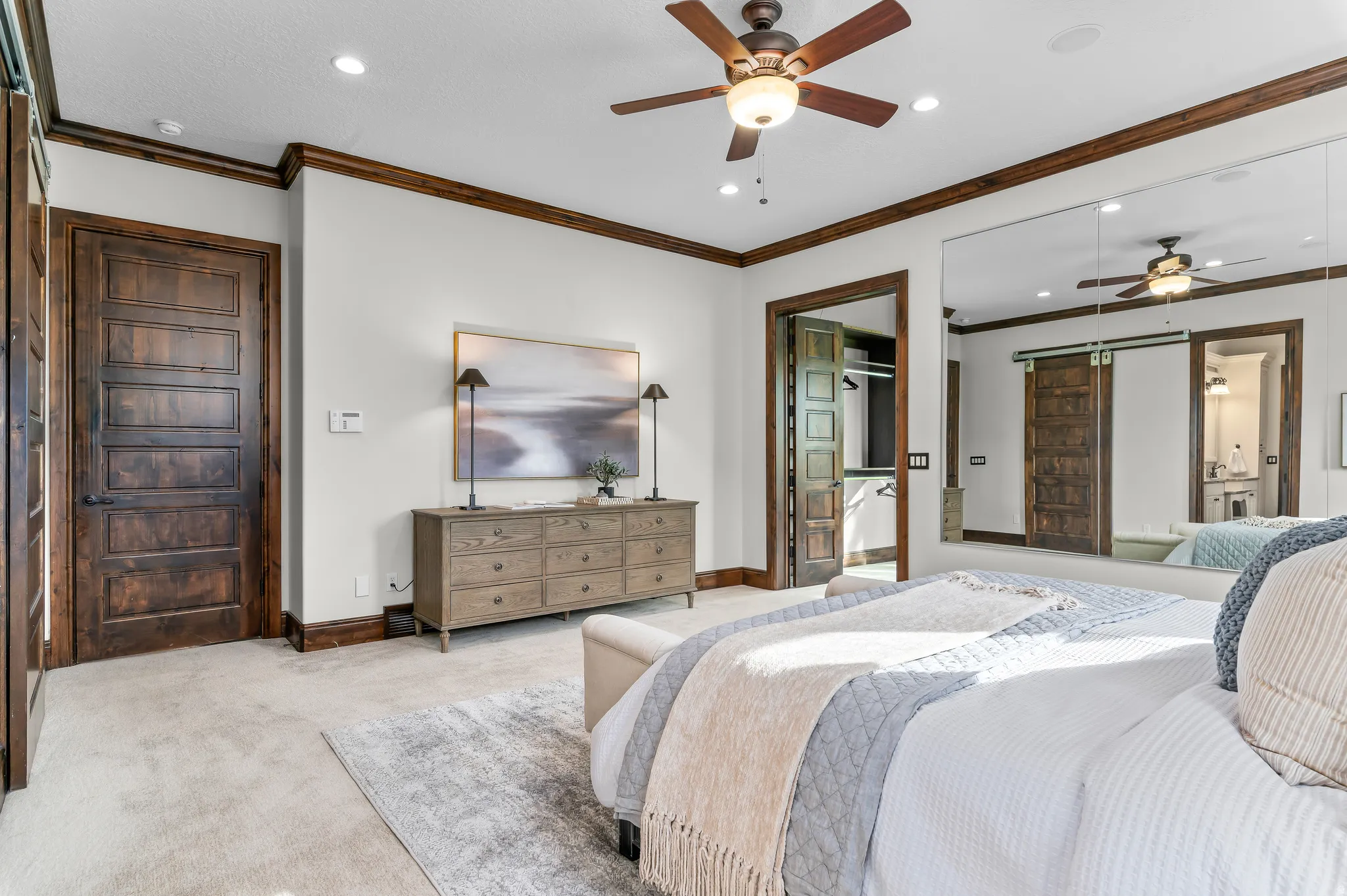 Recessed lighting with a ceiling fan, five-panel wood doors, wood-trim baseboards, and wall-mounted mirror panels