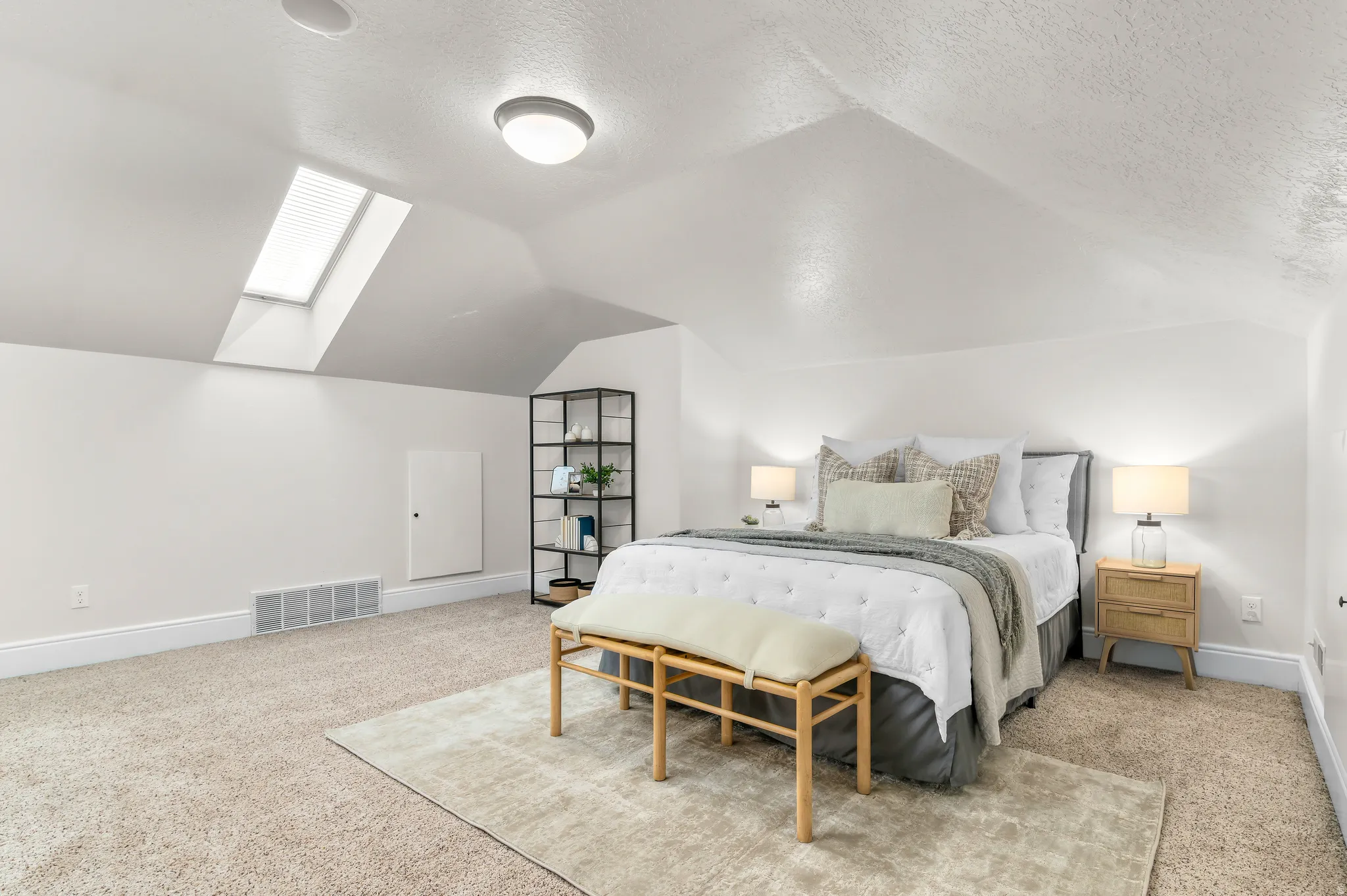 Carpeted room with a skylight, sloped ceiling, recessed lighting, and wall-mounted light fixtures