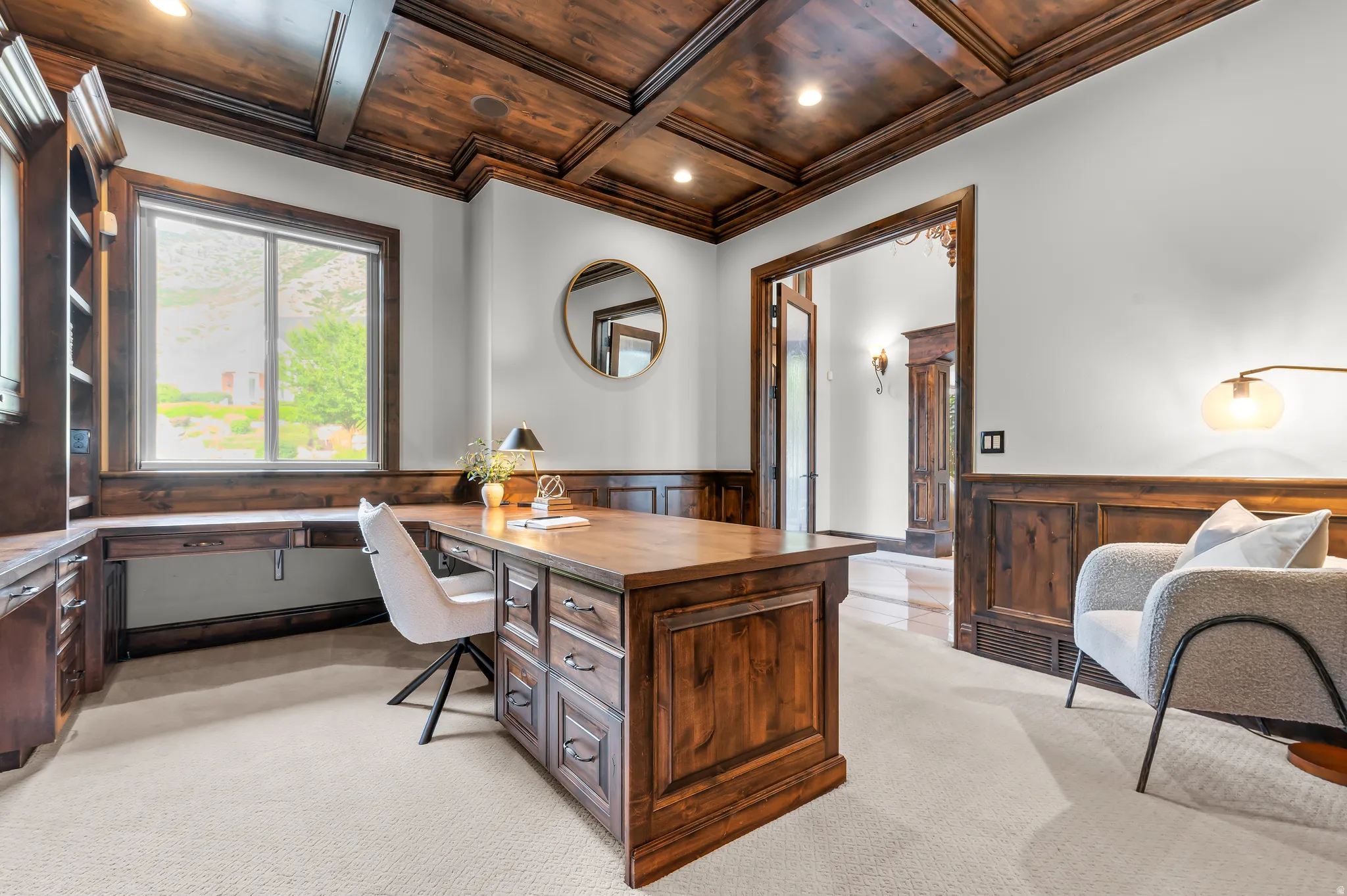 Coffered wood-finish ceiling, built-in wooden desk, built-in wooden shelving, wood-finish wainscoting, and carpet flooring