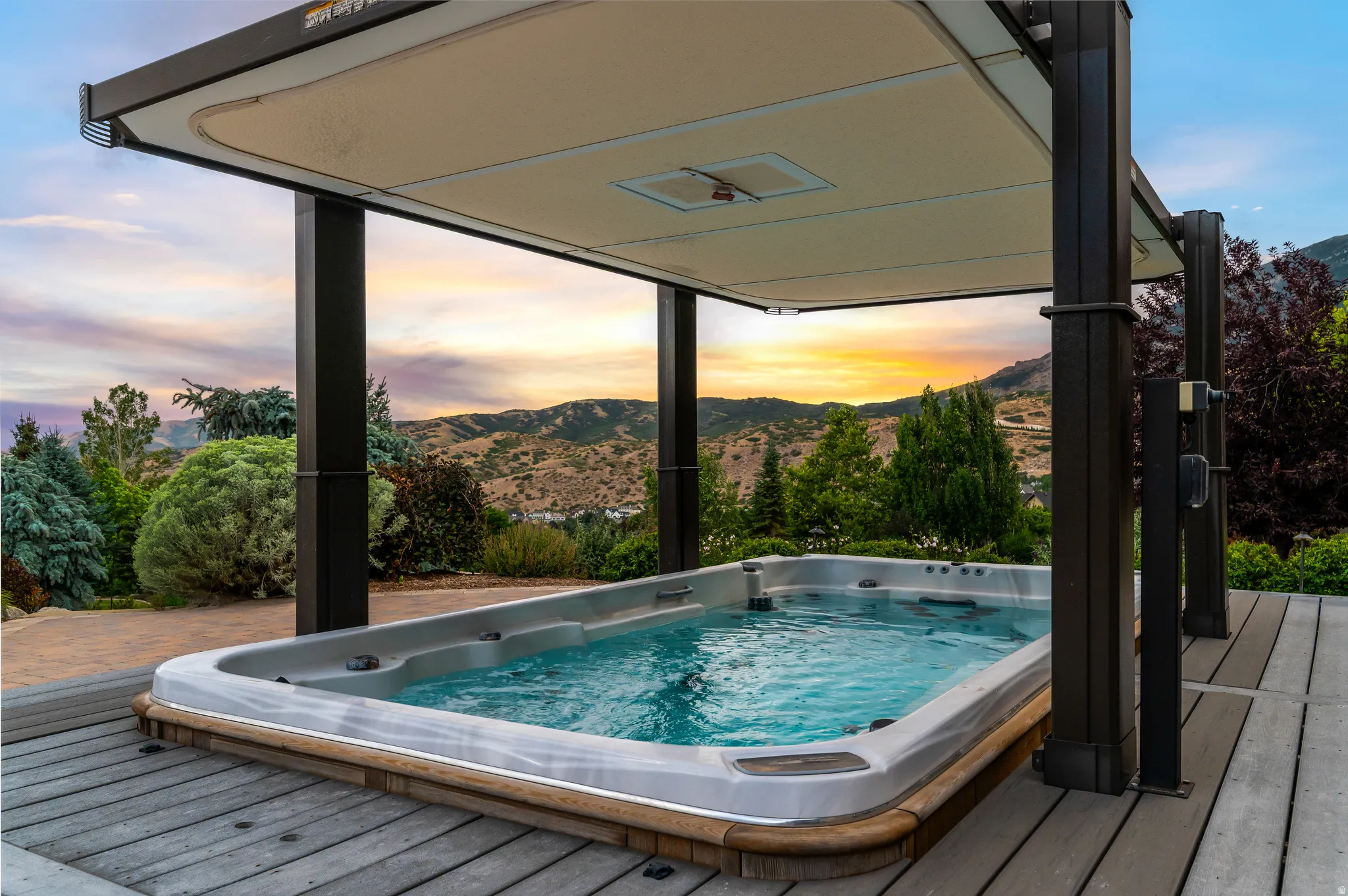 Outdoor spa with a retractable canopy, set on a multi-tone composite deck