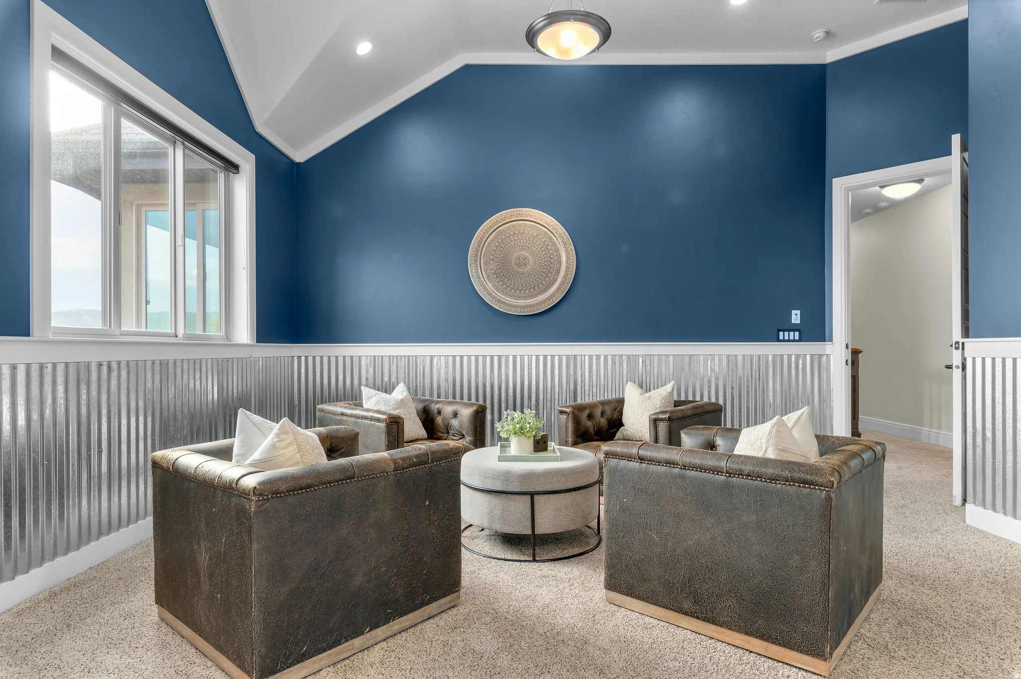 Accent wall featuring corrugated metal wainscoting and crown molding