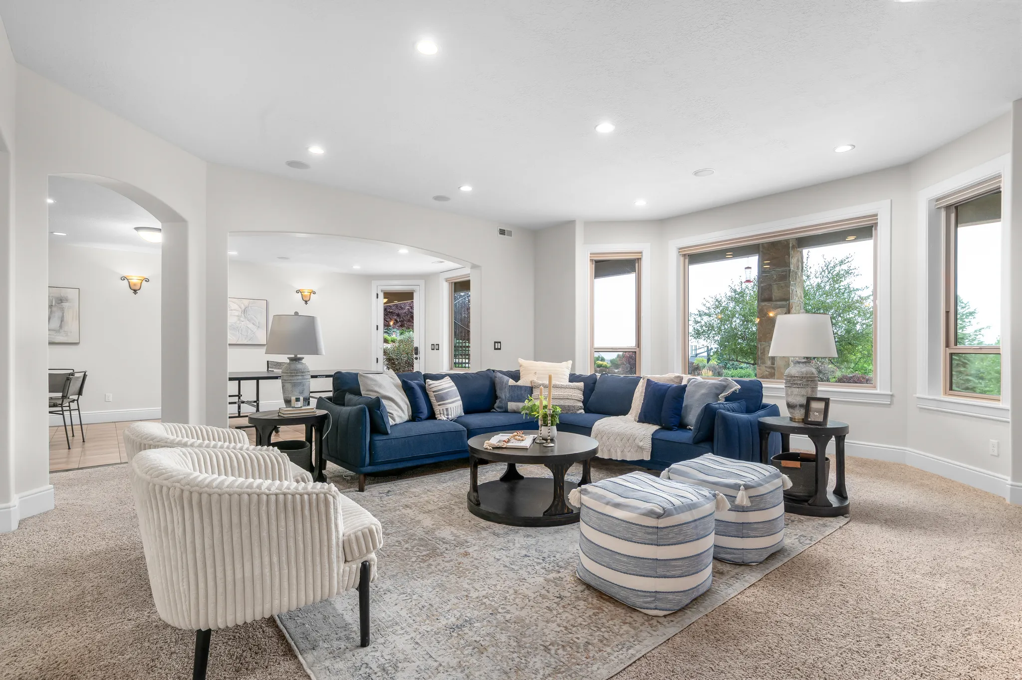 Arched doorways, recessed lighting, and large windows with integrated blinds