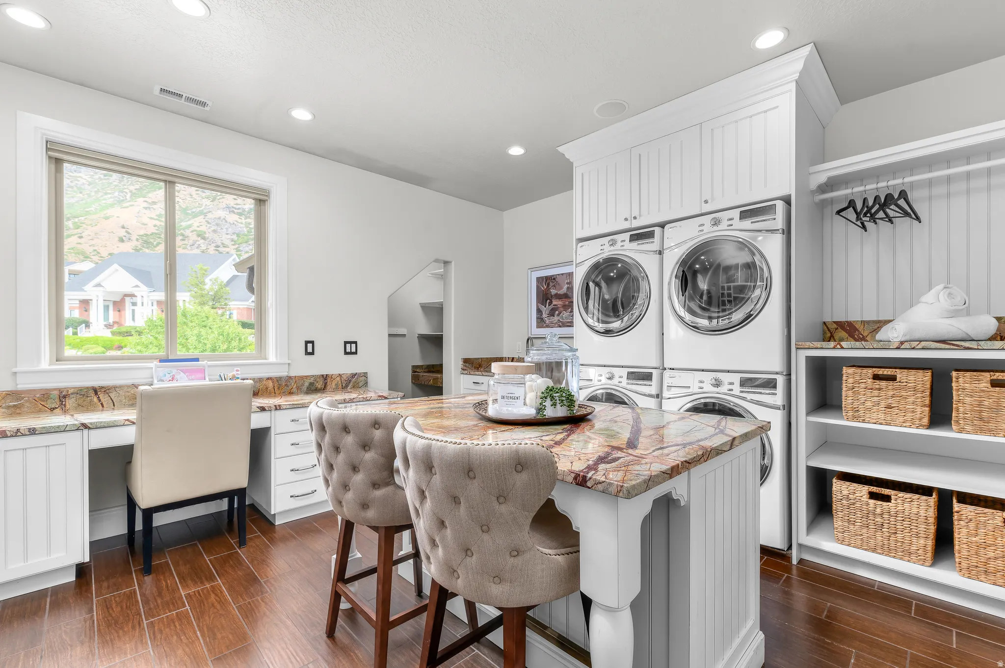 Laundry room featuring wood-finish flooring, a built-in desk, built-in shelving, a natural stone countertop, and recessed lighting