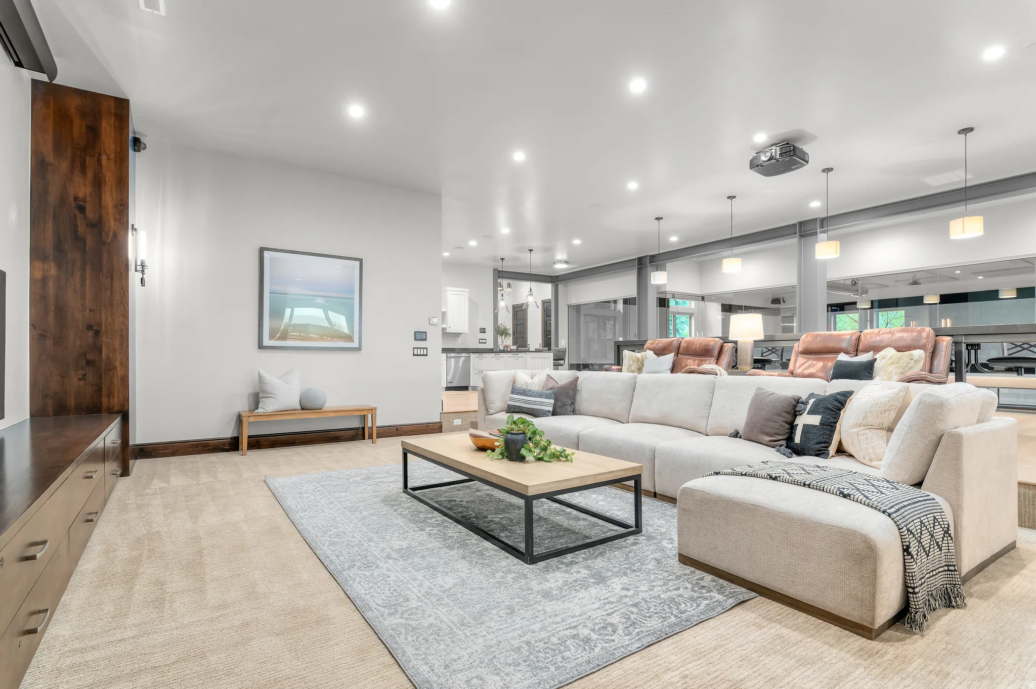 Recessed lighting illuminates the open-concept living space with carpet flooring