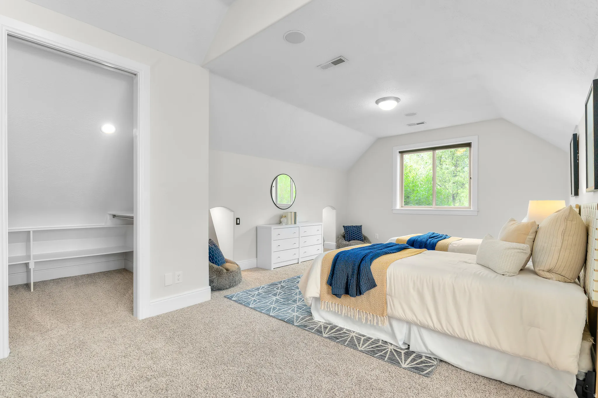 Carpeted room with vaulted ceilings and a window