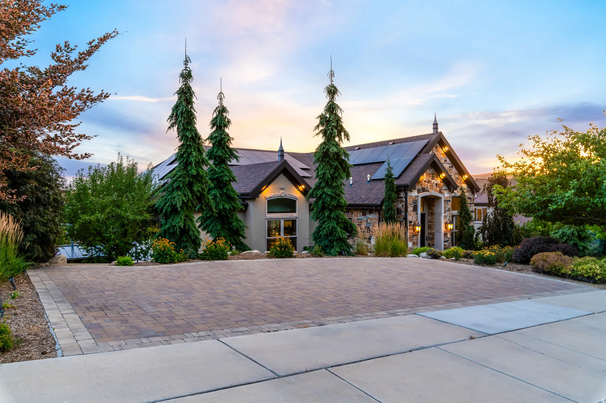 Stone facade detailing the home's exterior with a paver driveway