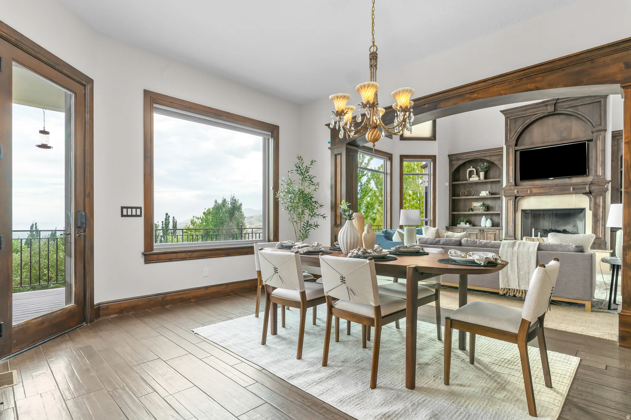 Wood-finish flooring, a large picture window, and a paneled glass door provide abundant natural light