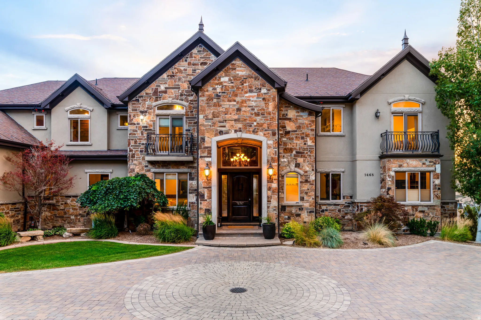 Stone and stucco exterior featuring multiple gables and arched window details