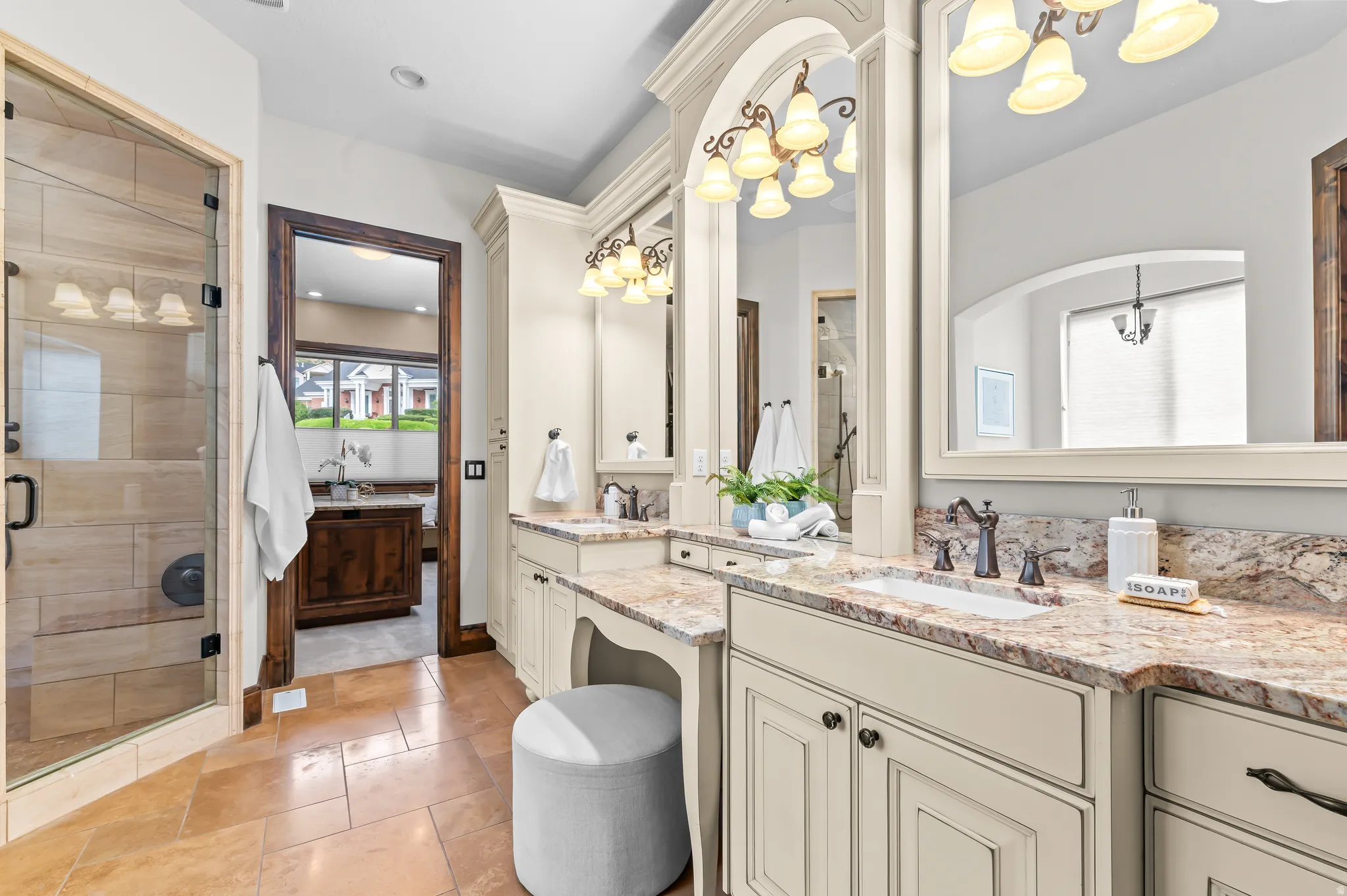 Double vanity with integrated sinks, framed mirrors, and ornate light fixtures
