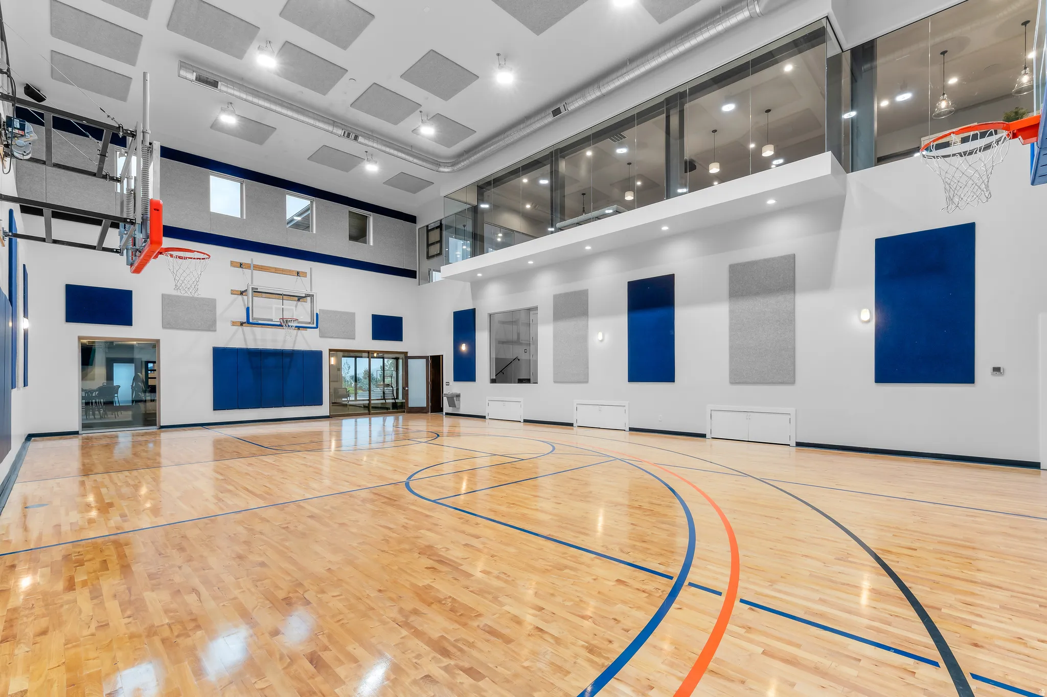 Indoor sports court with high ceilings, recessed lighting, polished wood flooring, and upper-level viewing area