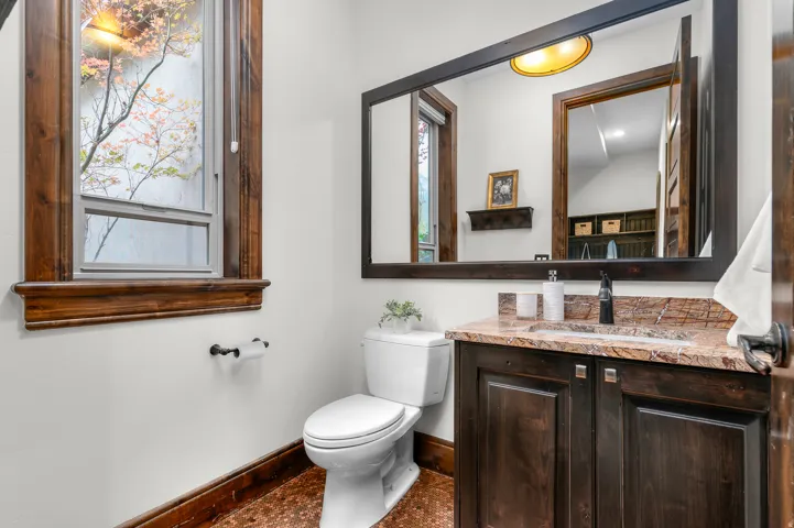 Dark wood-finish vanity with an integrated sink and stone countertop