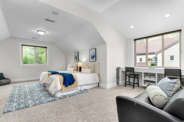 Carpeted room with sloped ceilings and recessed lighting