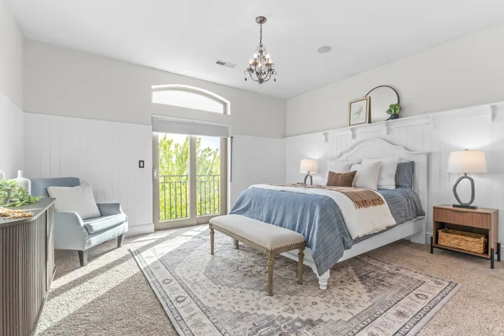 Board and batten wall detailing, arched transom window, French doors with balcony, recessed lighting, and a chandelier