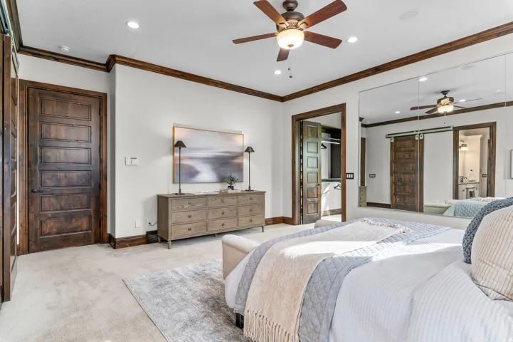 Recessed lighting with a ceiling fan, five-panel wood doors, wood-trim baseboards, and wall-mounted mirror panels
