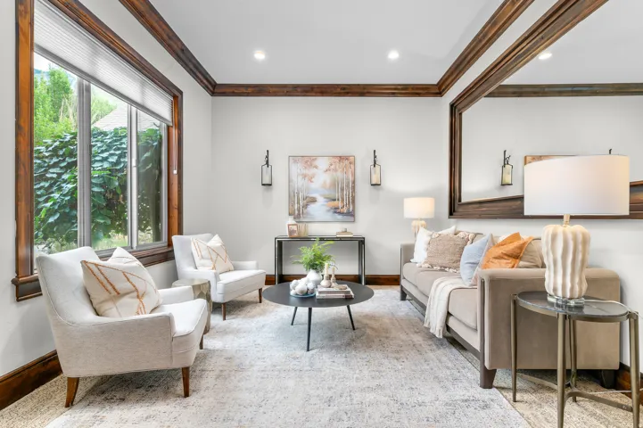 Recessed ceiling lights illuminate the room, highlighting the wood-framed window and coordinating decorative wall molding