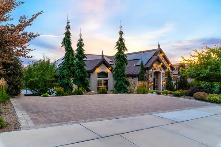 Stone facade detailing the home's exterior with a paver driveway
