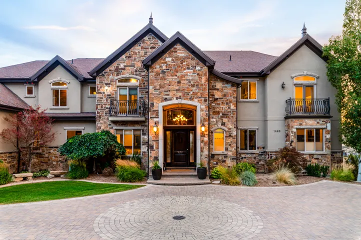 Stone and stucco exterior featuring multiple gables and arched window details