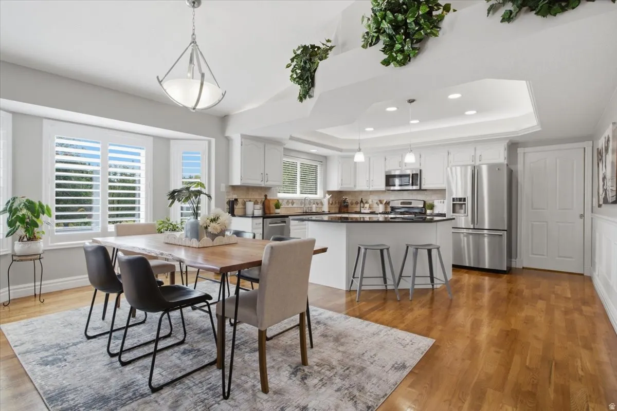 Open dining and kitchen area filled with natural light, hardwood floors and plenty of gathering space.