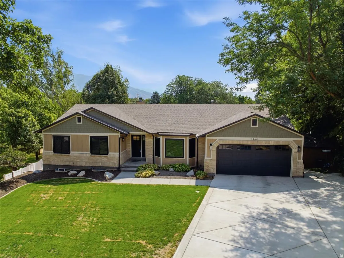 Elevated exterior view highlights the home's mature setting, generous lawn and established landscaping.