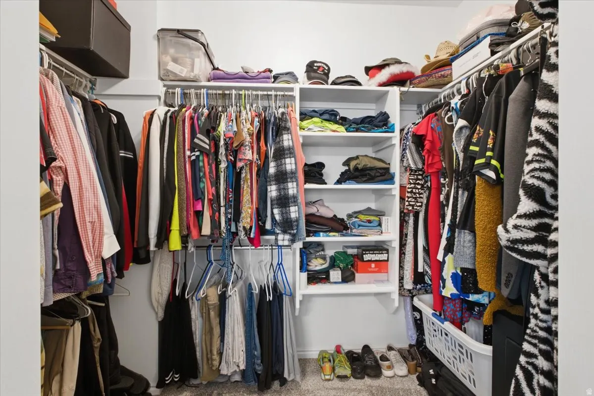 Walk-in primary closet provides excellent hanging space, shelving and organized storage.