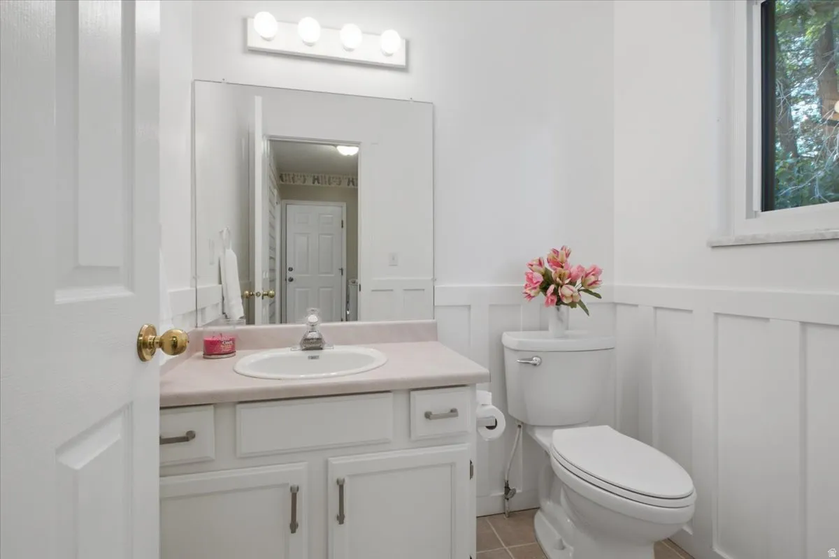 Convenient additional bath with bright finishes and classic wainscoting details.