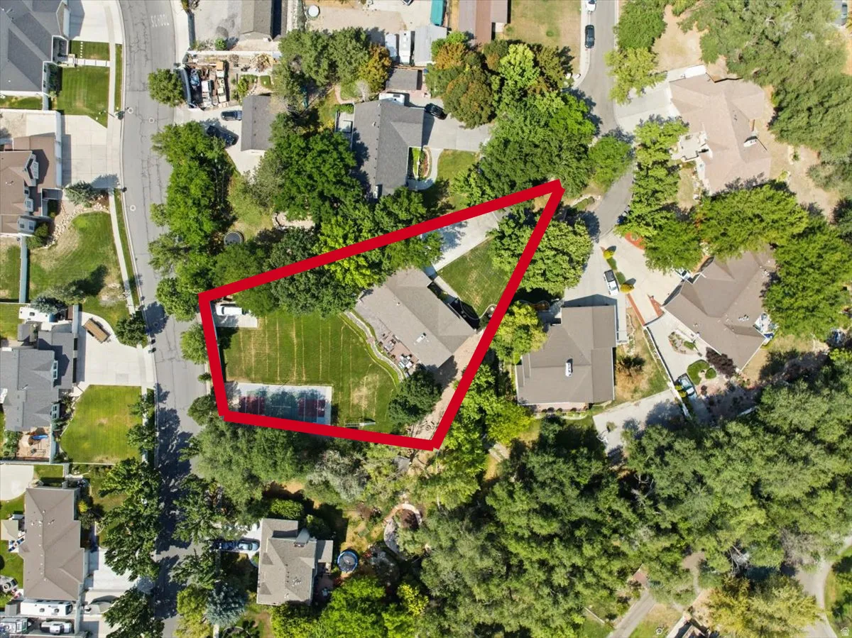 ]Top-down aerial reveals the size and layout of the .57-acre property, including the sport court and mature trees.