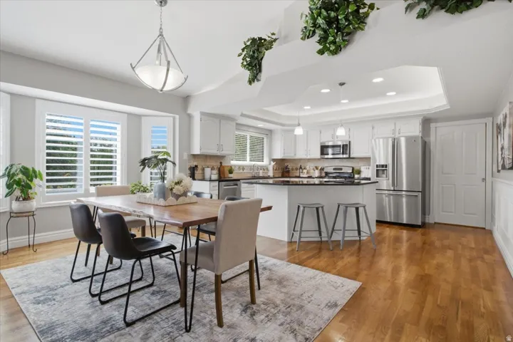 Open dining and kitchen area filled with natural light, hardwood floors and plenty of gathering space.