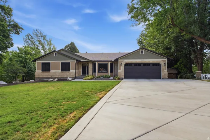Classic rambler-style home with an expansive driveway, updated exterior and welcoming curb appeal.