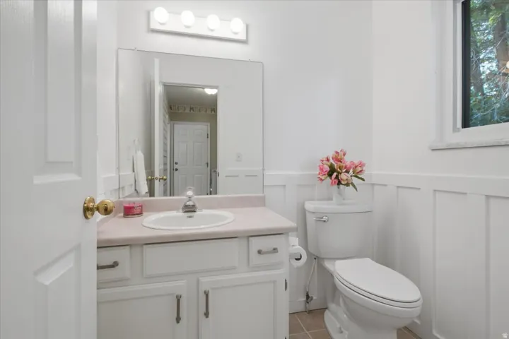Convenient additional bath with bright finishes and classic wainscoting details.