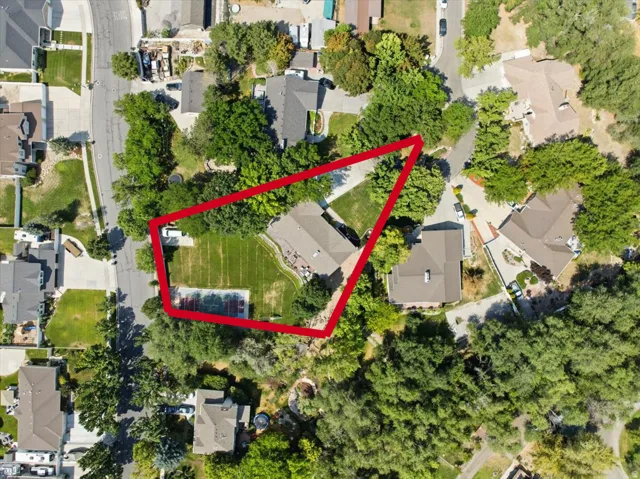 ]Top-down aerial reveals the size and layout of the .57-acre property, including the sport court and mature trees.