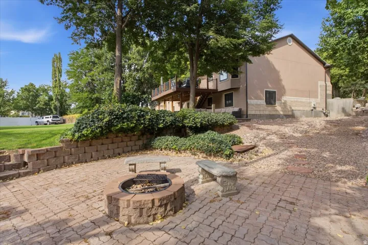 Tucked beneath mature trees, the backyard fire pit offers a charming outdoor gathering space.