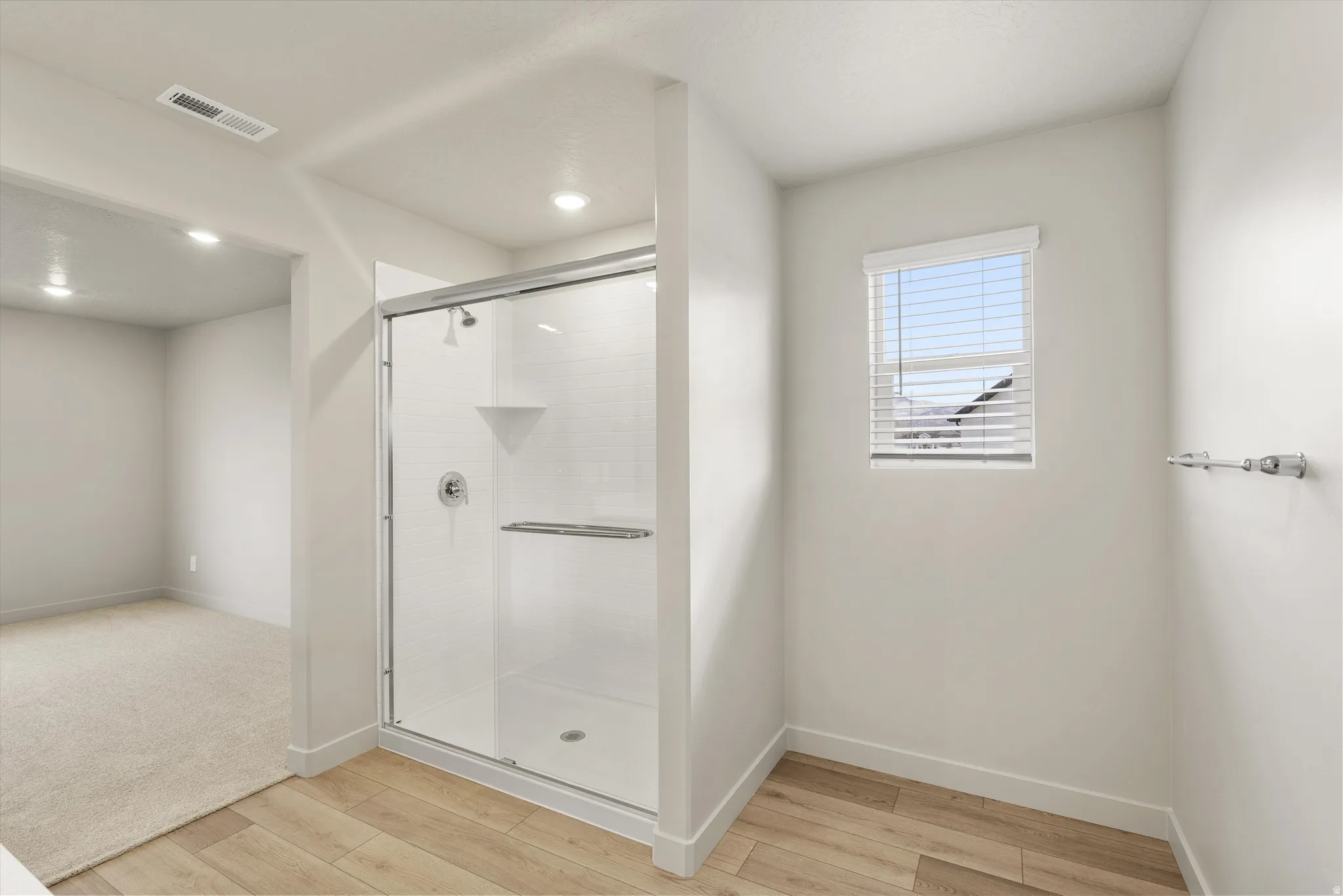 **DISCLAIMER** This floorplan has upgrades not photographed.Enclosed shower with clear glass door, white subway tile surround, and chrome fixtures