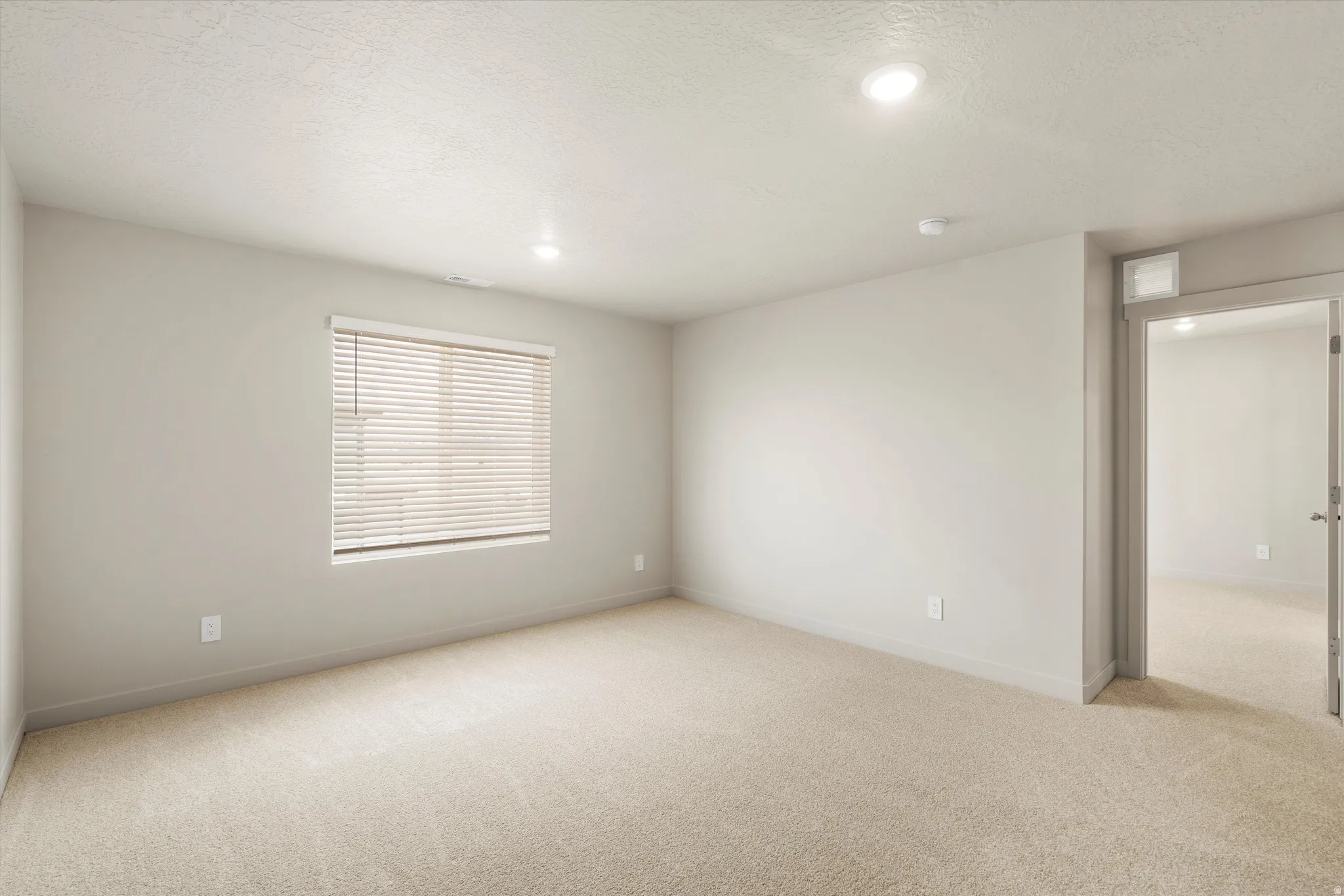 **DISCLAIMER** This floorplan has upgrades not photographed.Recessed lighting, neutral wall tones, window with horizontal blinds, neutral carpeting, and a doorway