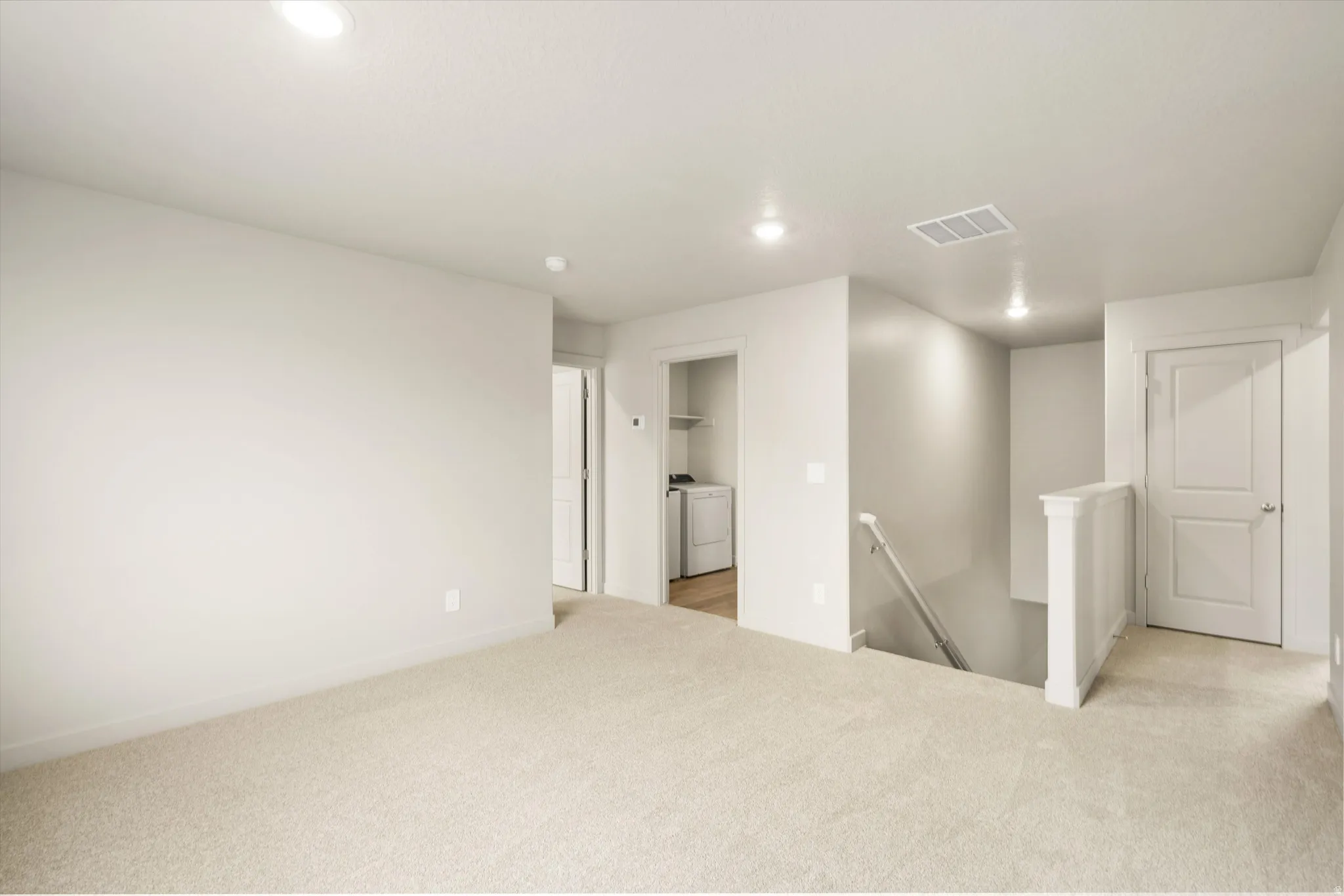 **DISCLAIMER** This floorplan has upgrades not photographed.Carpeted landing area featuring recessed lighting, a laundry alcove with built-in shelving, and a paneled door