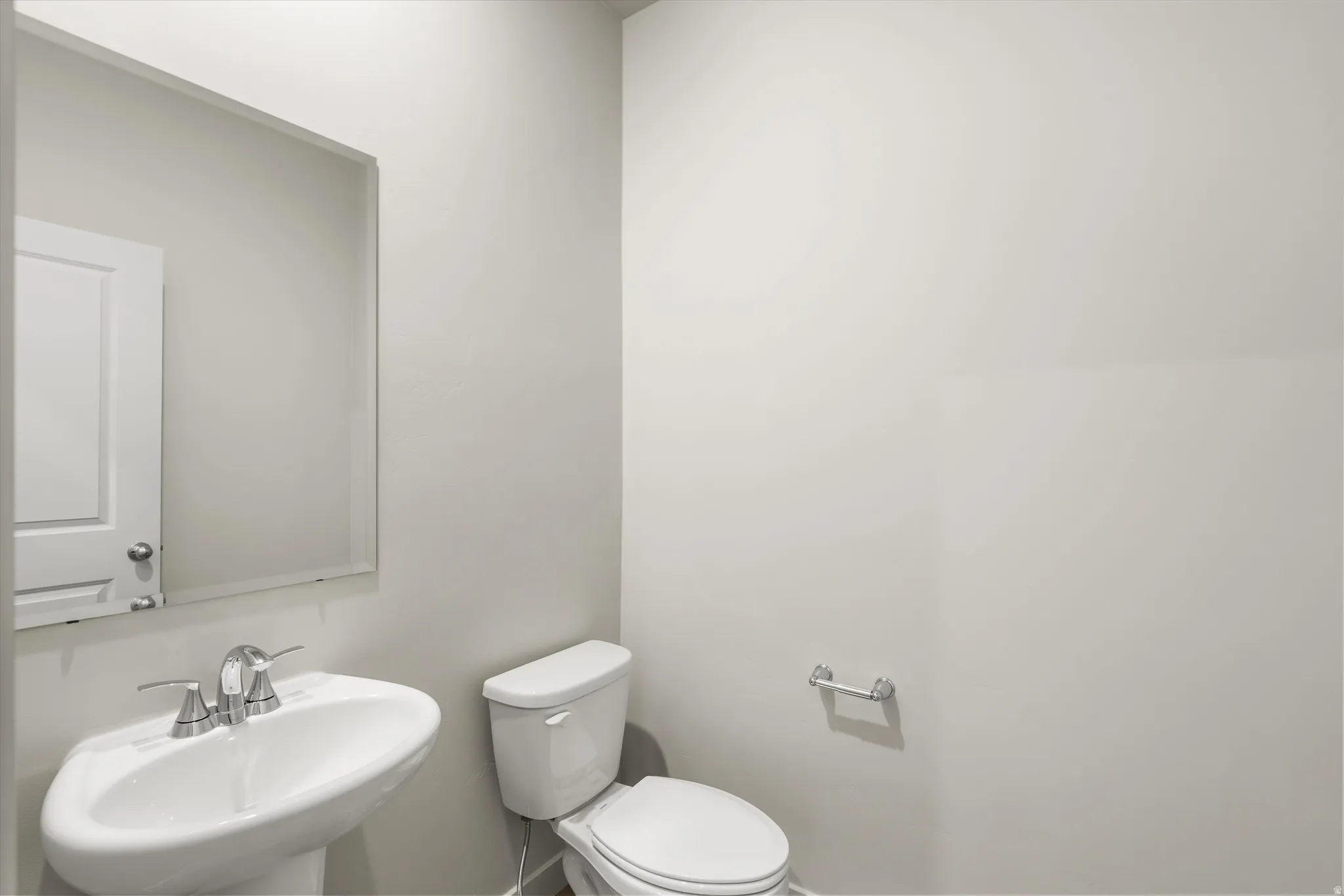 **DISCLAIMER** This floorplan has upgrades not photographed.Pedestal sink with chrome fixtures and a rectangular mirror