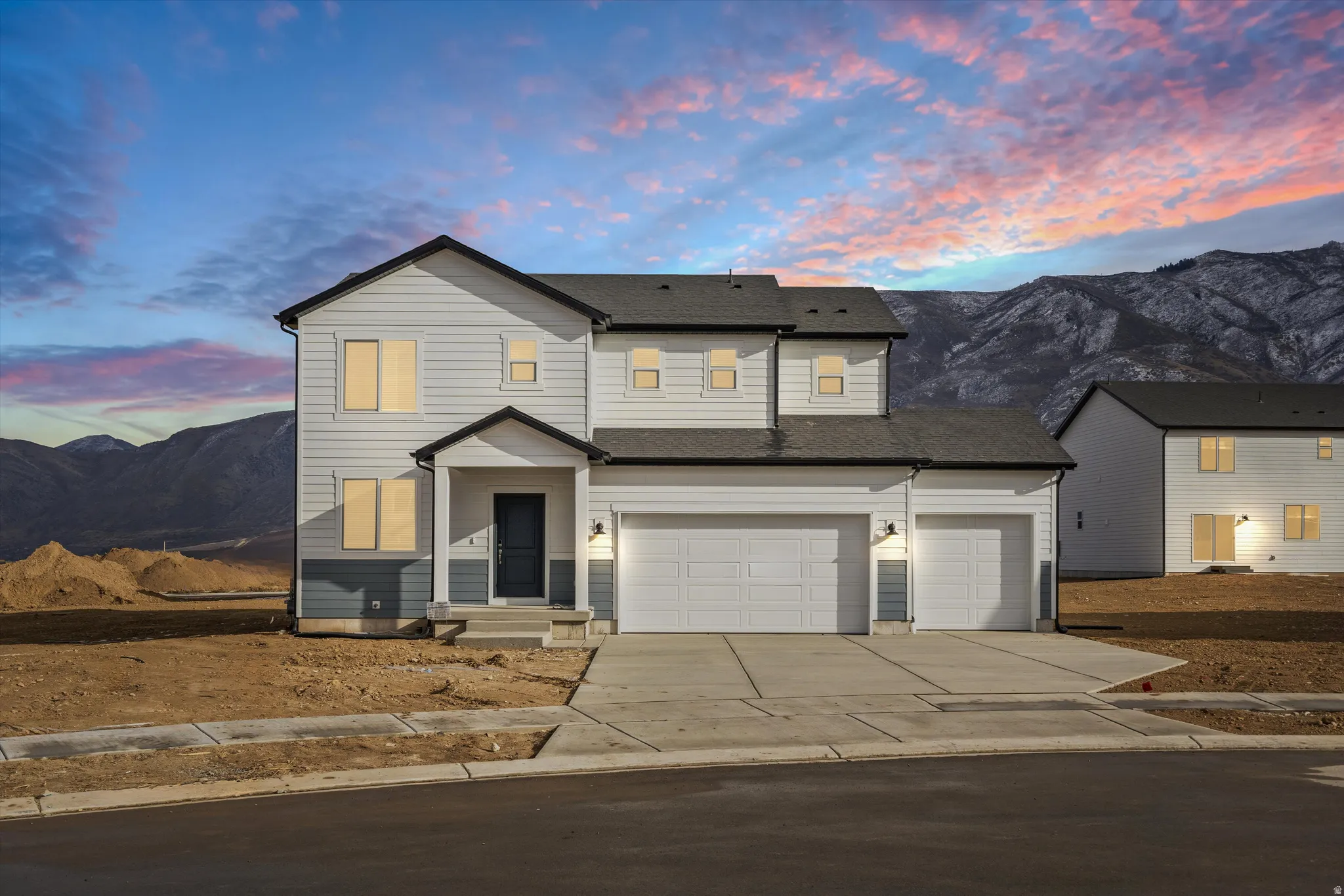 Two-story residence with a covered entry, two-car garage, and a single-car garage