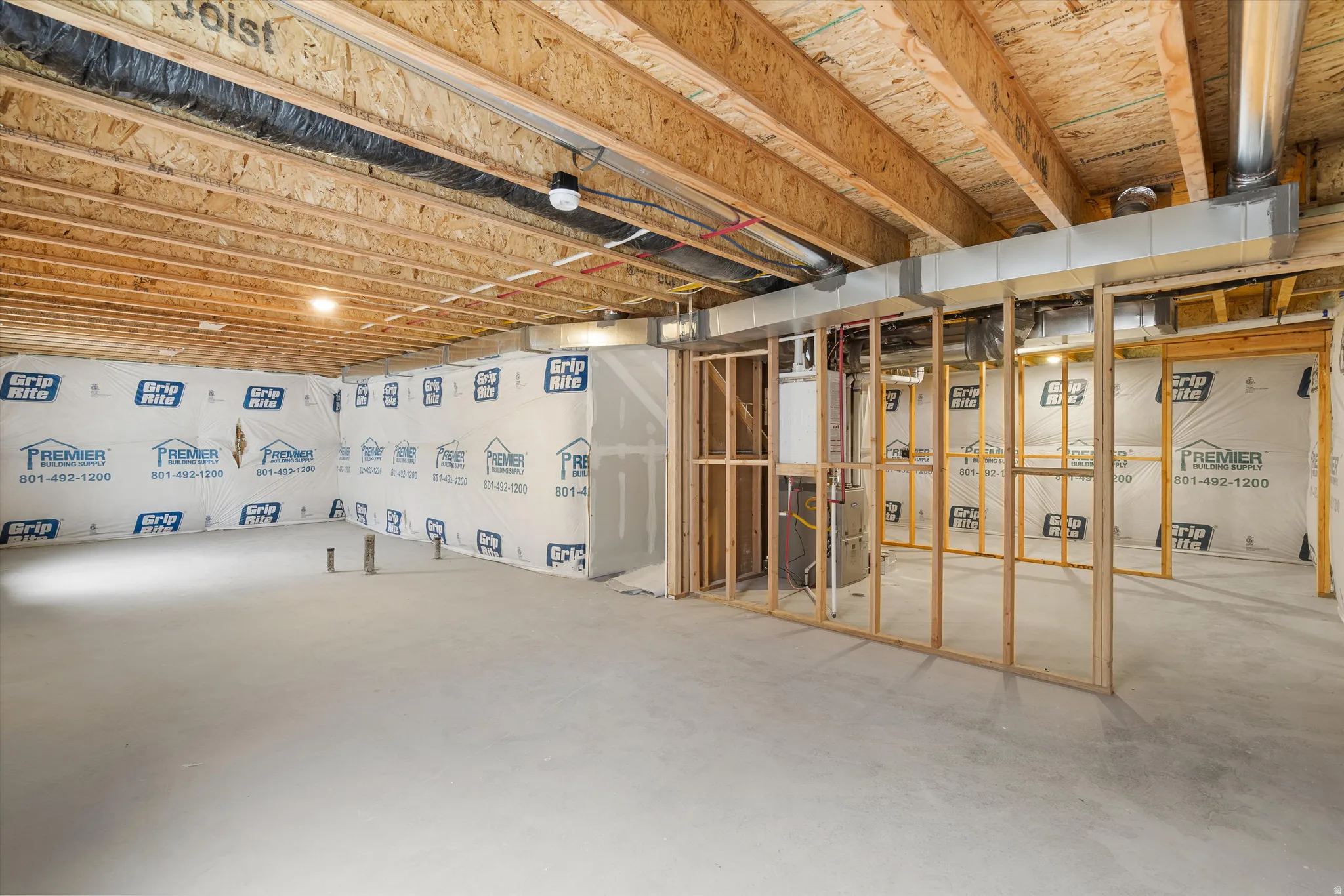 Unfinished basement with exposed ceiling joists and concrete flooring