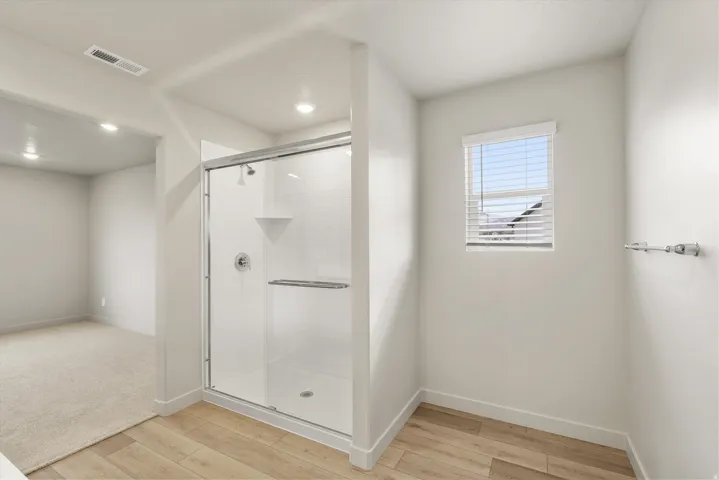 **DISCLAIMER** This floorplan has upgrades not photographed.Enclosed shower with clear glass door, white subway tile surround, and chrome fixtures