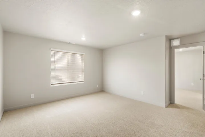 **DISCLAIMER** This floorplan has upgrades not photographed.Recessed lighting, neutral wall tones, window with horizontal blinds, neutral carpeting, and a doorway