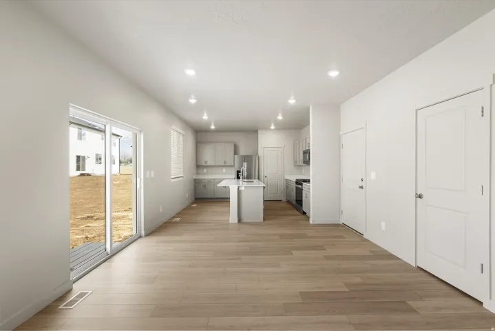 **DISCLAIMER** This floorplan has upgrades not photographed.Open-concept living space with wood-finish flooring, a contemporary kitchen island, and recessed lighting