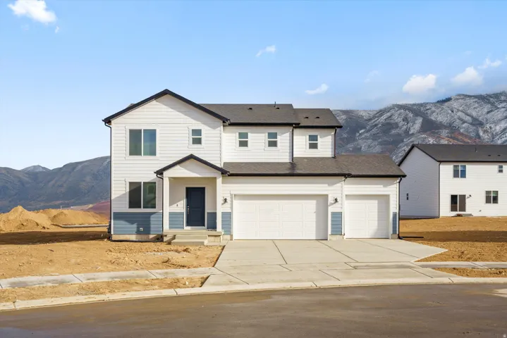Two-story residence with a covered entry, attached three-car garage, and a concrete driveway