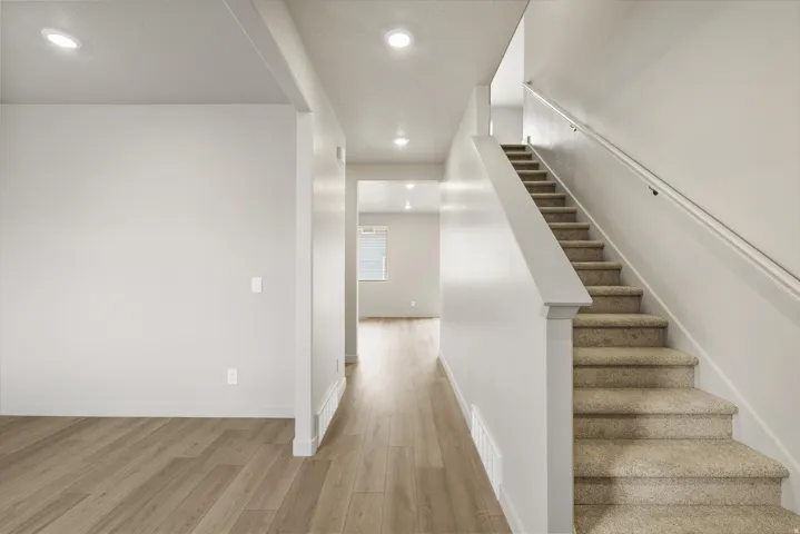**DISCLAIMER** This floorplan has upgrades not photographed.Light-toned wood-finish flooring, recessed lighting, carpeted staircase, white railing, and neutral wall tones