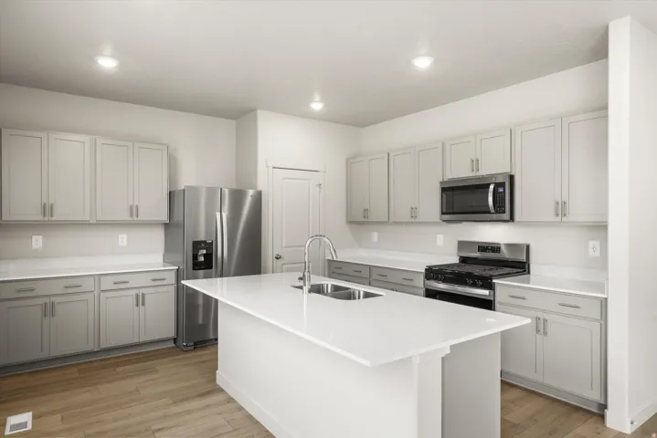 **DISCLAIMER** This floorplan has upgrades not photographed.Kitchen featuring a central island, light-toned cabinetry, stainless steel appliances, wood-finish flooring, and recessed lighting