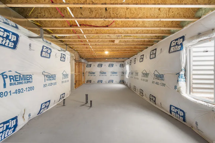 Unfinished lower level featuring exposed ceiling joists, framed walls, and concrete flooring