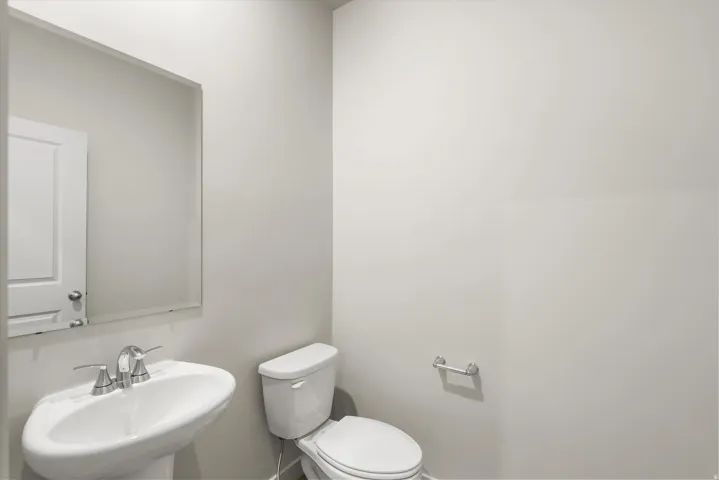 **DISCLAIMER** This floorplan has upgrades not photographed.Pedestal sink with chrome fixtures and a rectangular mirror