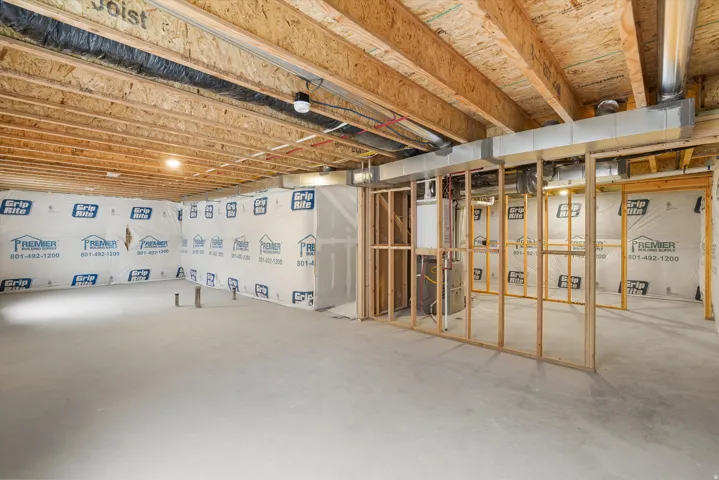 Unfinished basement with exposed ceiling joists and concrete flooring