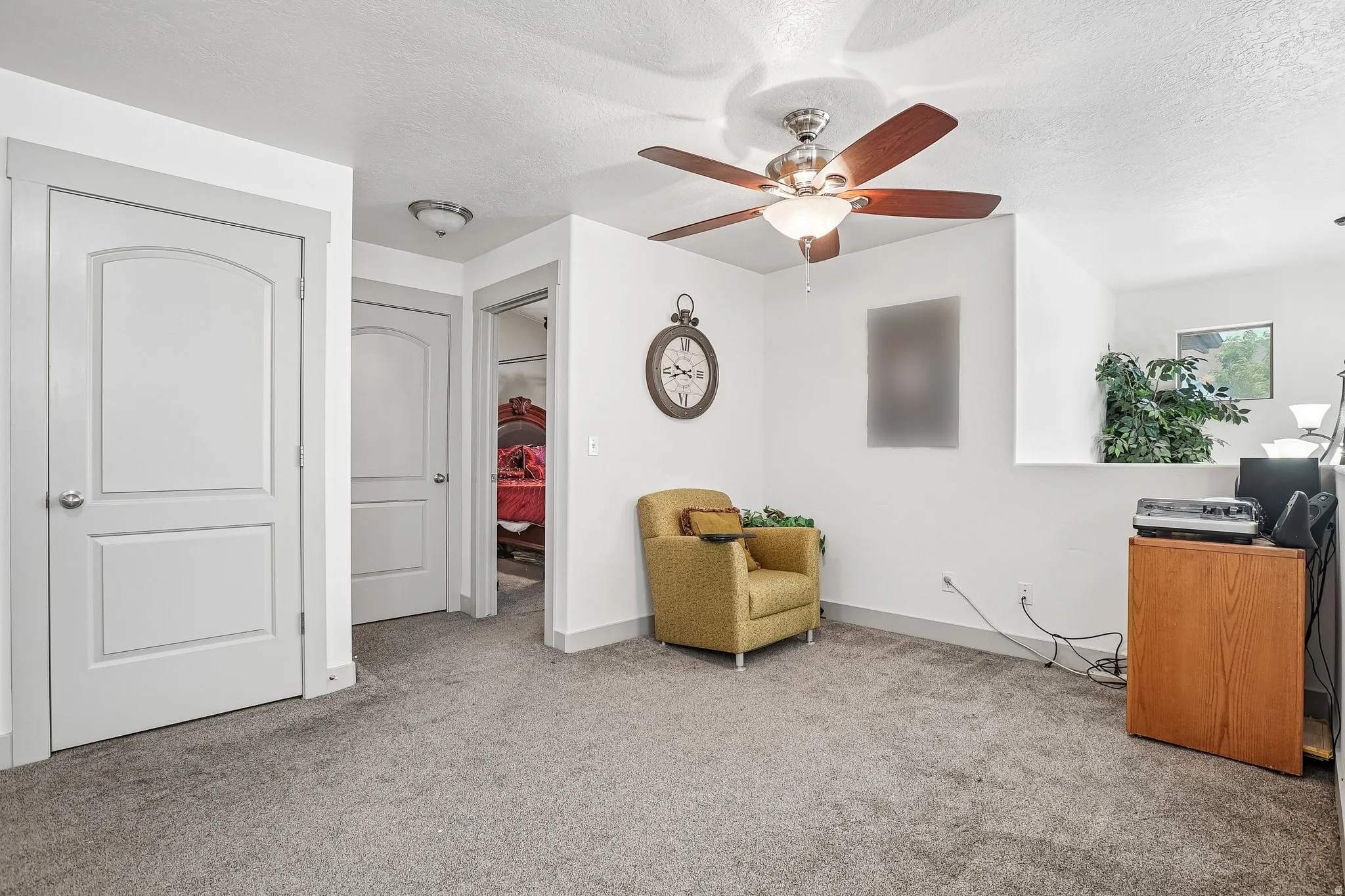 Ceiling fan with light fixture, carpeted flooring, white walls, and white interior doors