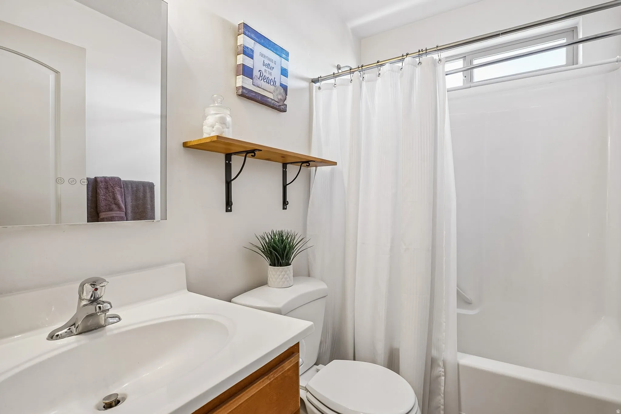 Integrated vanity with a single basin sink, chrome faucet, and wood-finish cabinetry